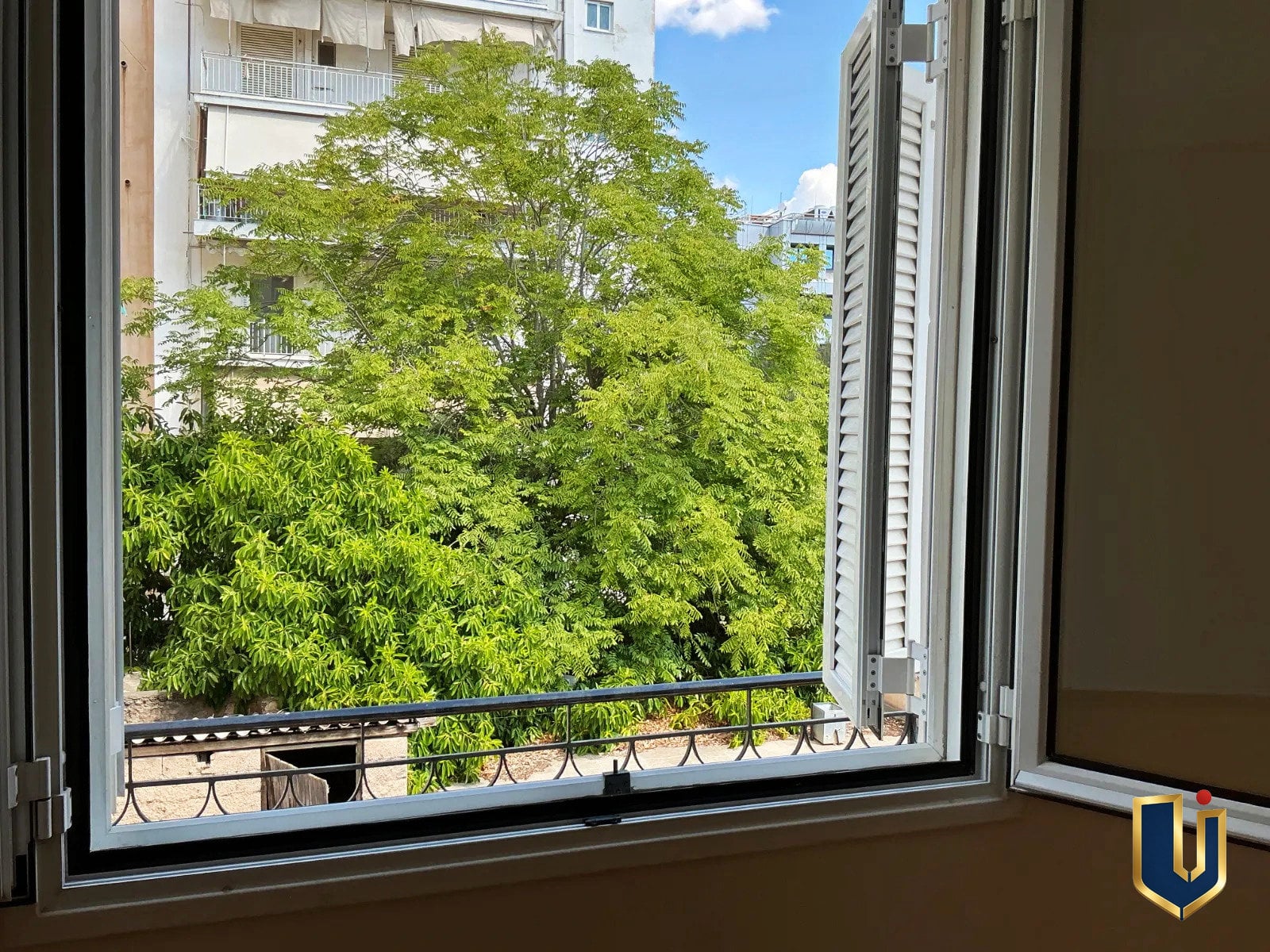 Διαμέρισμα στην Κυπριάδου – Άνω Πατήσια | Urban Keys Real Estate Athens Ανοιχτό παράθυρο υπνοδωματίου με θέα σε πράσινο, σε διαμέρισμα στην Κυπριάδου – Άνω Πατήσια.