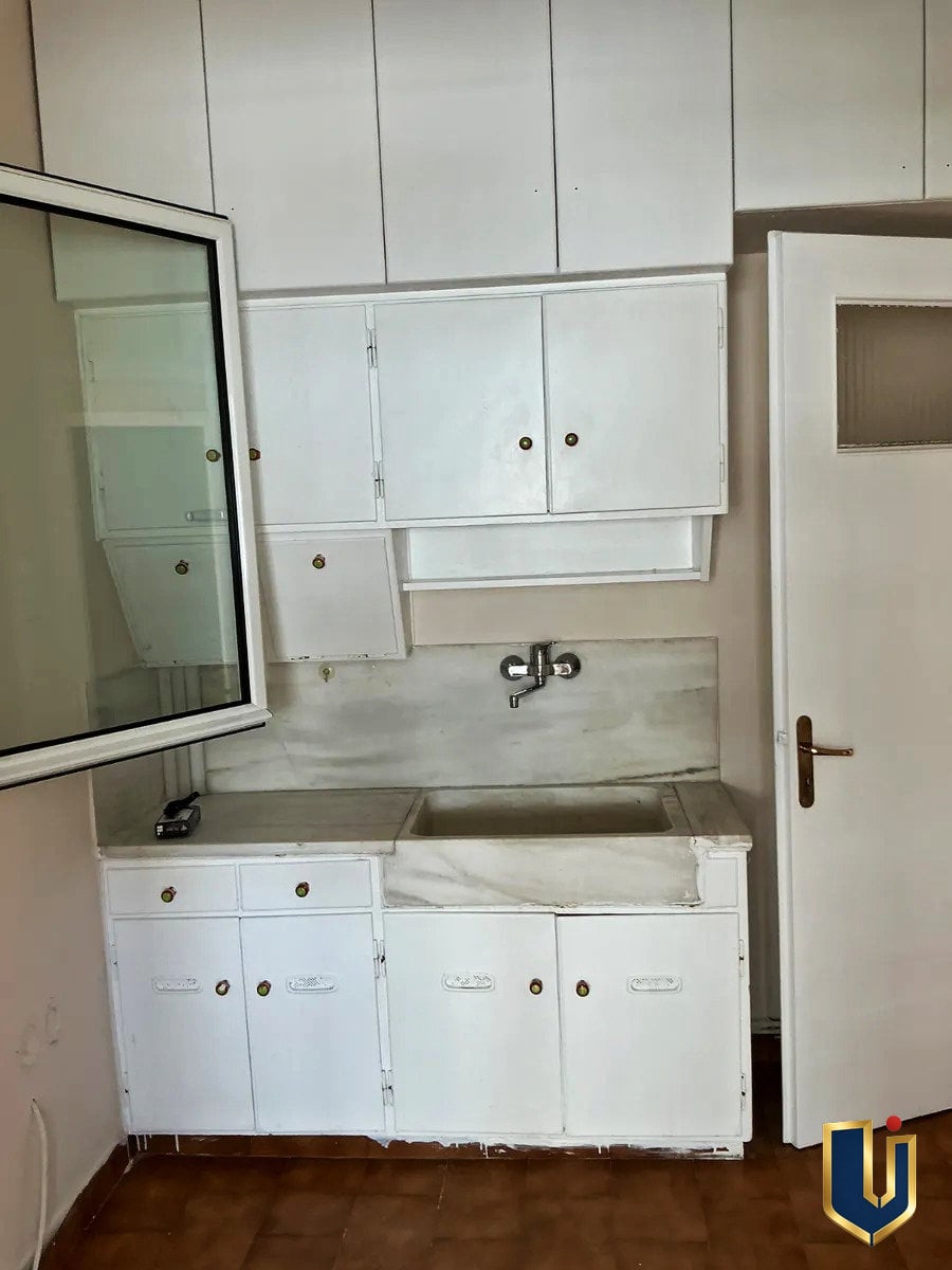 Κουζίνα με ντουλάπια στην Κυπριάδου | Urban Keys Athens Κουζίνα με λευκά ντουλάπια, νεροχύτη και παράθυρο σε διαμέρισμα στην Κυπριάδου – Άνω Πατήσια.