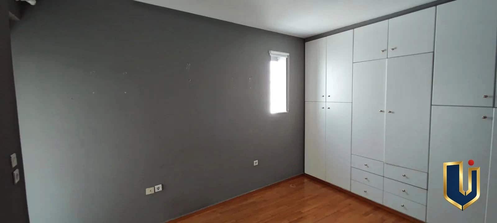 Υπνοδωμάτιο με ντουλάπα στον Άγιο Ελευθέριο | 150-1048 Υπνοδωμάτιο με λευκή ντουλάπα, γκρι τοίχους και στενό παράθυρο, σε διαμέρισμα στον Άγιο Ελευθέριο Αθήνας.