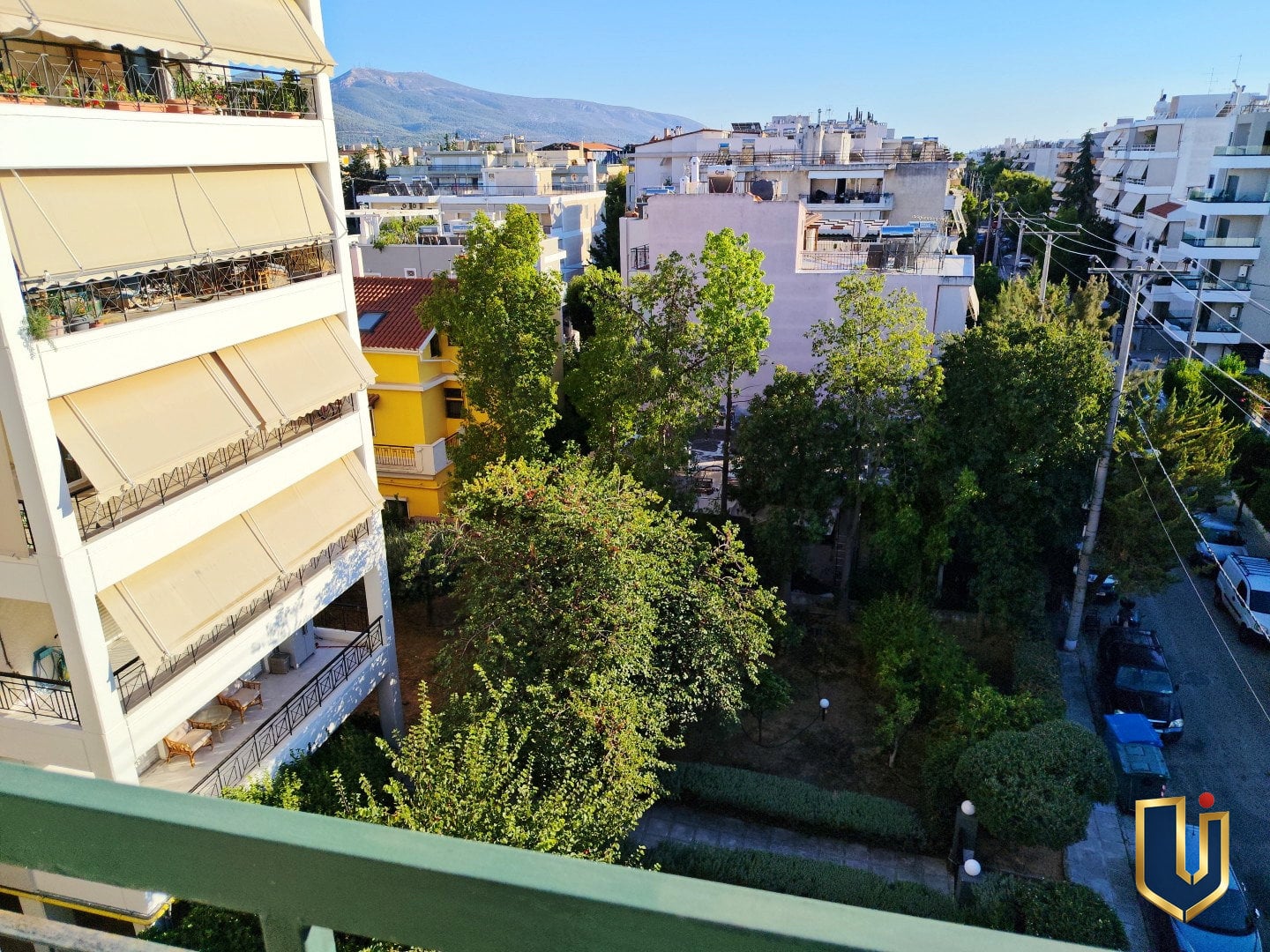 Νότια θέα προς κήπους και Υμηττό – Ρετιρέ Μαρούσι | 150-1051 Θέα από το νότιο μπαλκόνι σε κήπους και πολυκατοικίες στον Παράδεισο Αμαρουσίου, με το όρος Υμηττός στο βάθος.